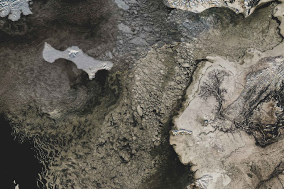 aerial view of snow covered ice drifts amongst rocky outcroppings