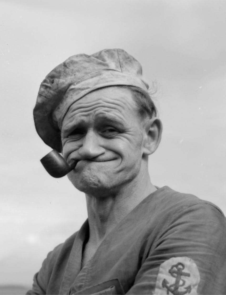 old black and white image of a sailor smoking a pipe with a face evocative of popeye