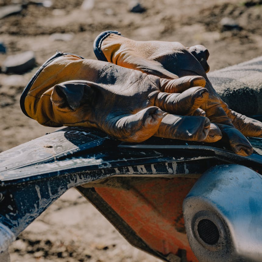 worn, dirty gloves on the tail of a motorcycle