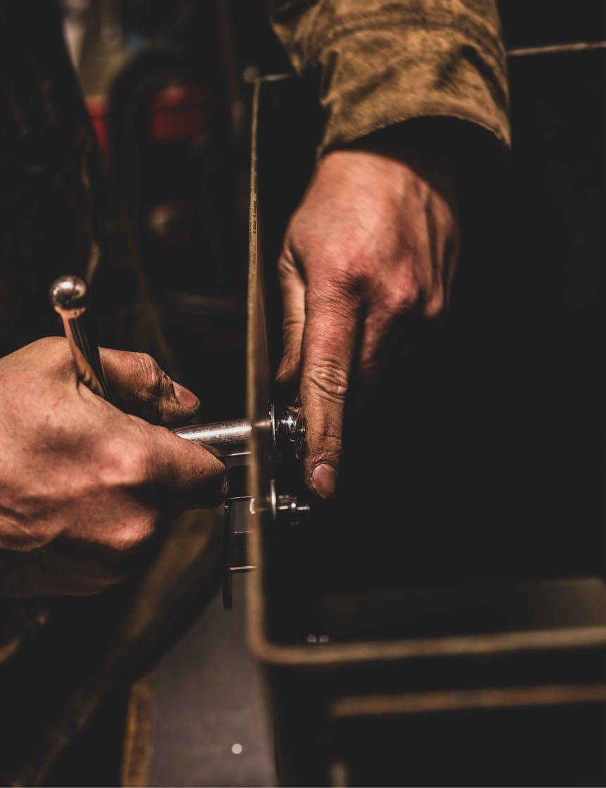 hands attaching hangers to the side of an ammo cannister