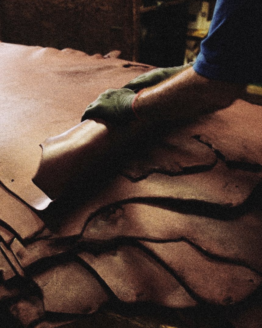 Hands rolling leather hides.