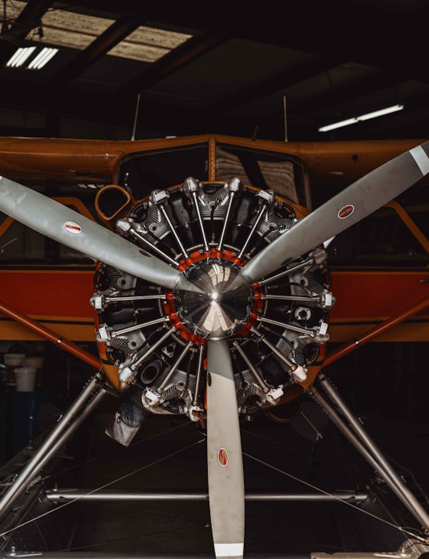 close up image of the front of a orange and red float plane