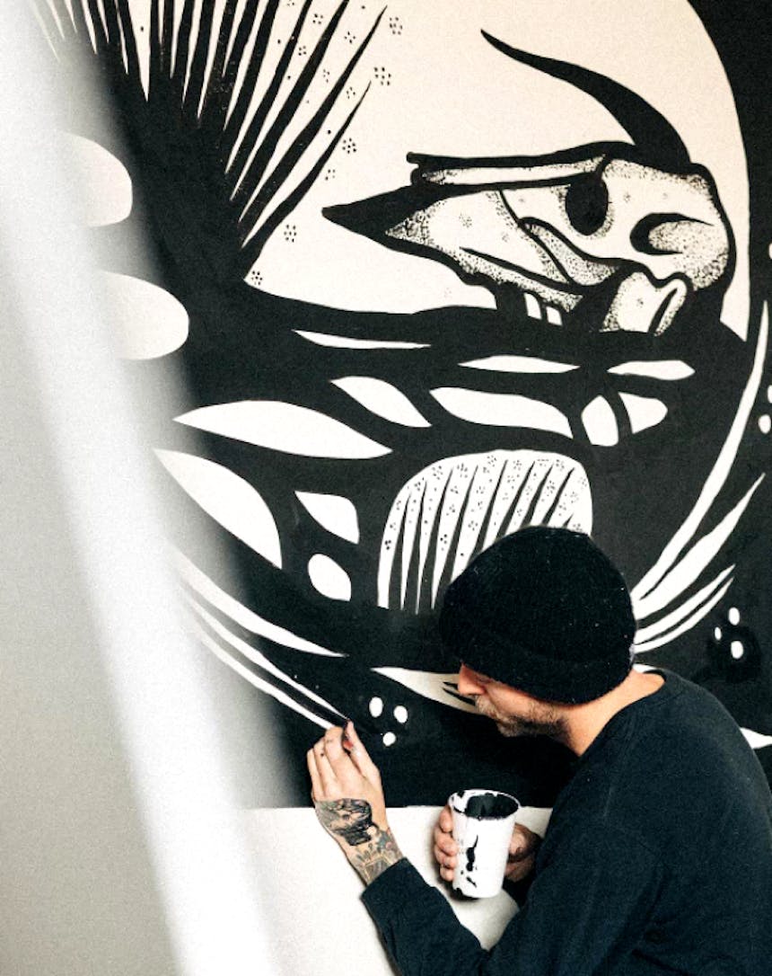 an artist painting a piece using only black and white