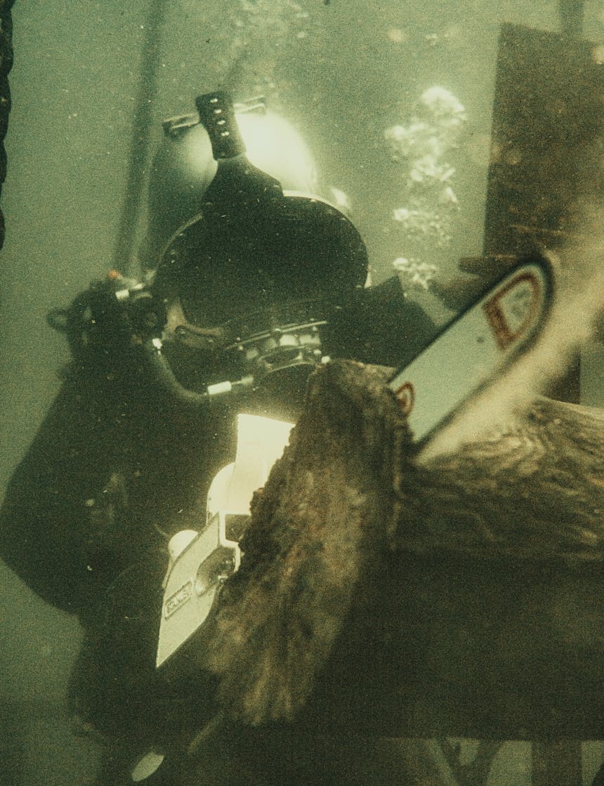 diver chainsawing underwater
