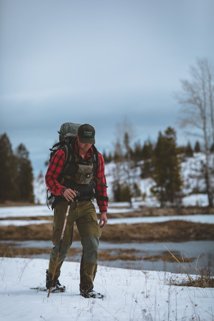 man on snowshoes hiking through deep snow