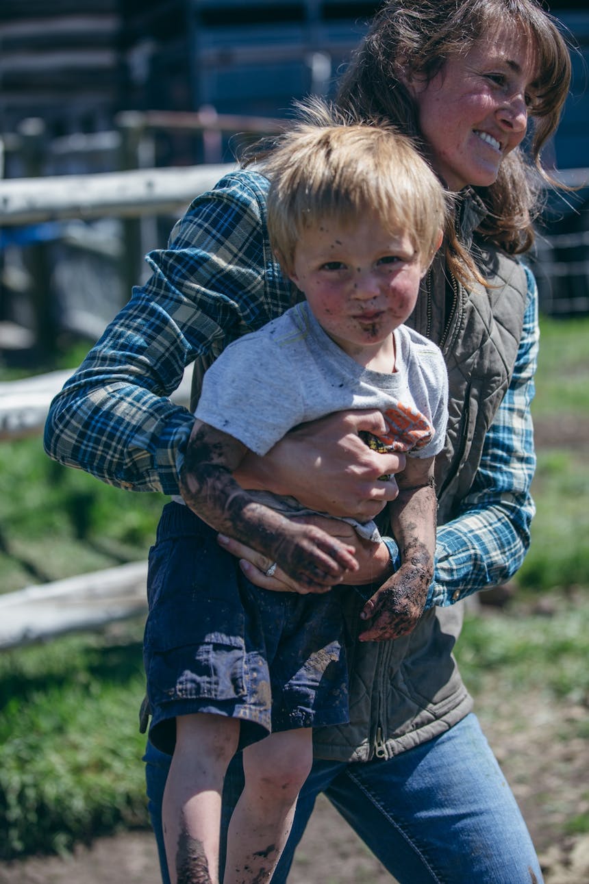 Hilary carrying her son, both laughing 