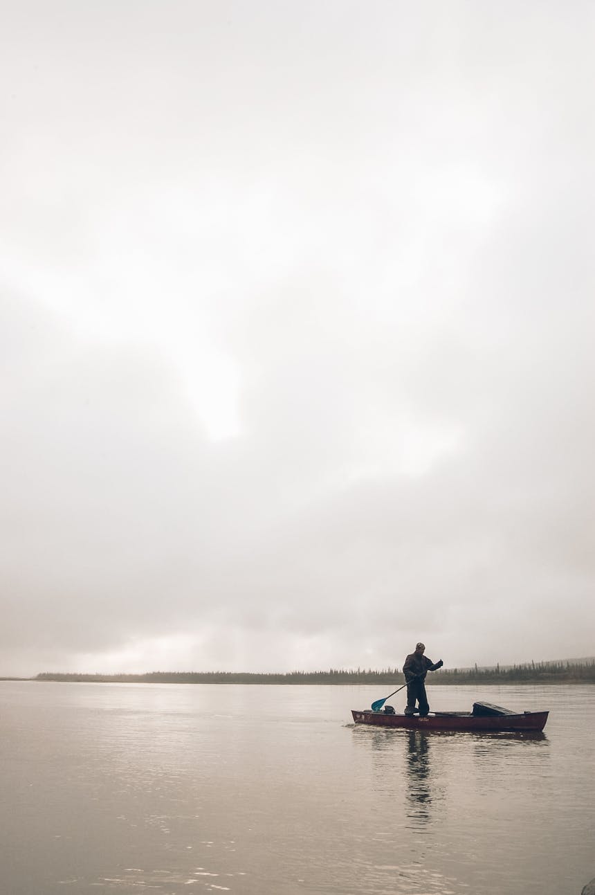 man paddling a canoe 