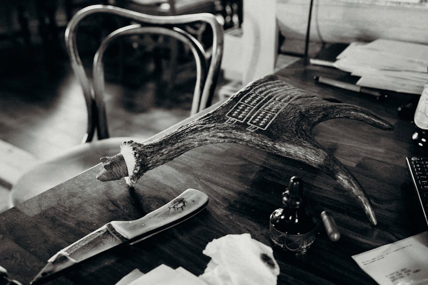cribbage board made from moose antler on desk with bone handle knife