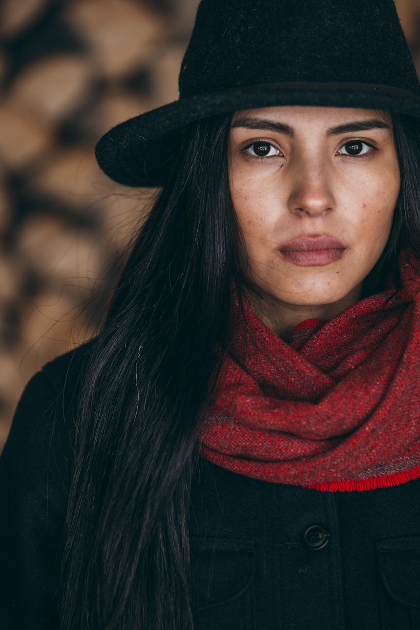 Keya portrait in black hat, red scarf and black jacket