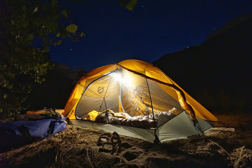 tent camping with light under starry sky