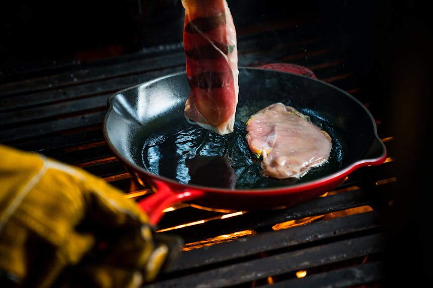 cooking breasts with prosciutto in red cast iron skillet