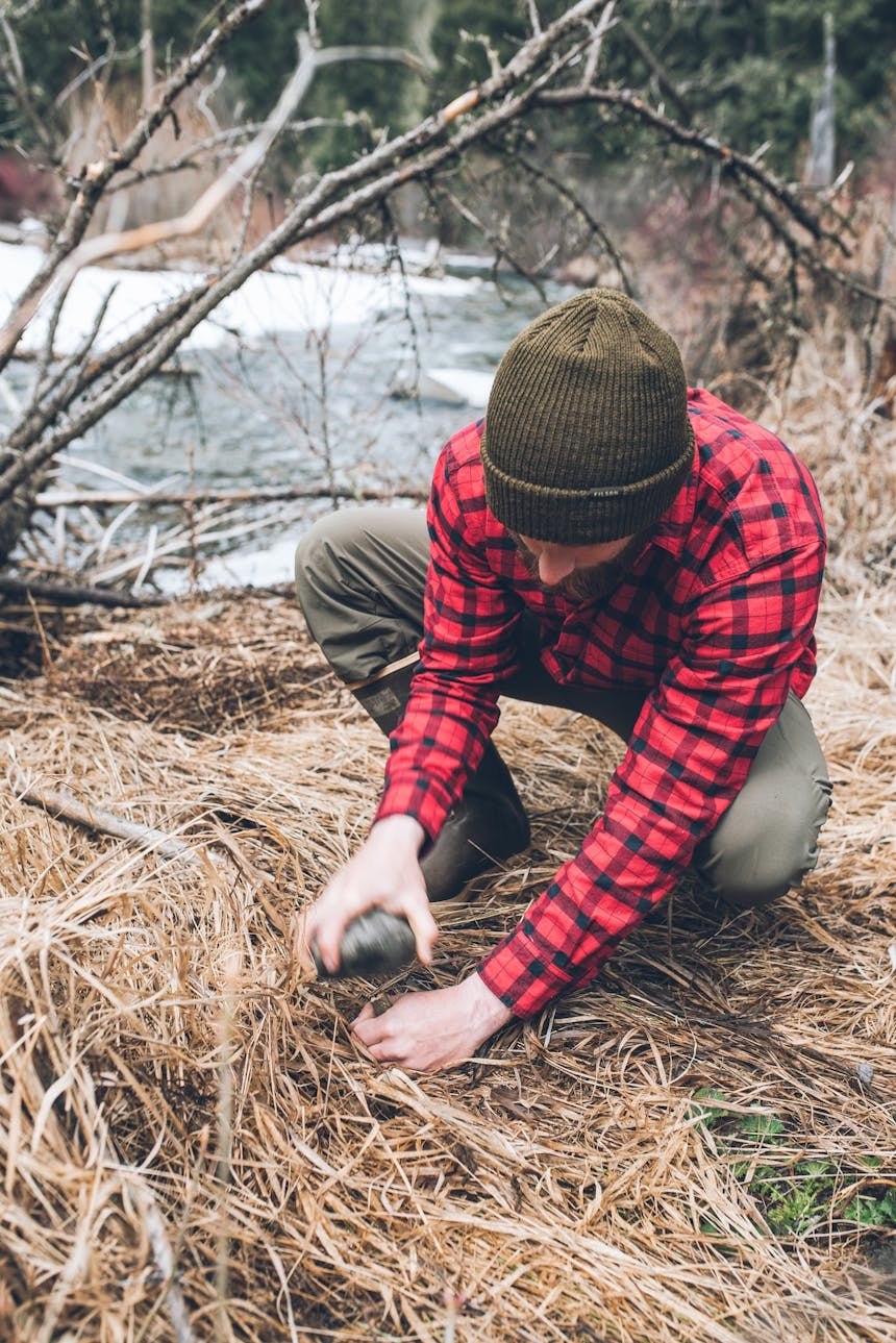 pounding the stakes into the ground with a rock